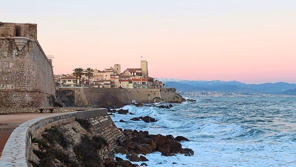 Blick auf die historische Altstadt von Antibes mit Festungsmauer am Mittelmeer bei Sonnenuntergang – ein Highlight unter den Tagesausflügen ab Nizza.