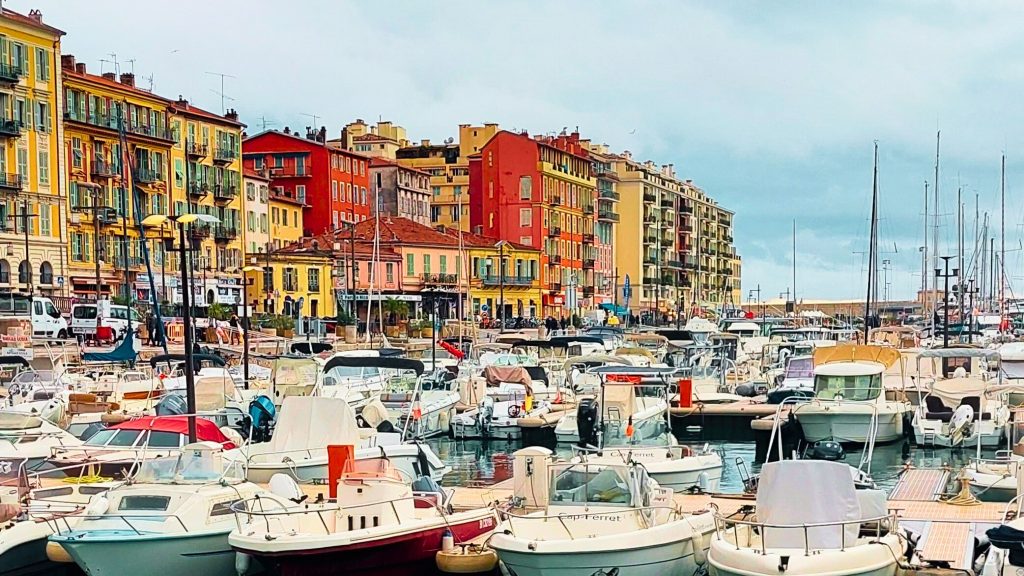 Port Lympia, der Hafen von Nizza, mit bunten Häuserfassaden und zahlreichen Booten an der Côte d’Azur