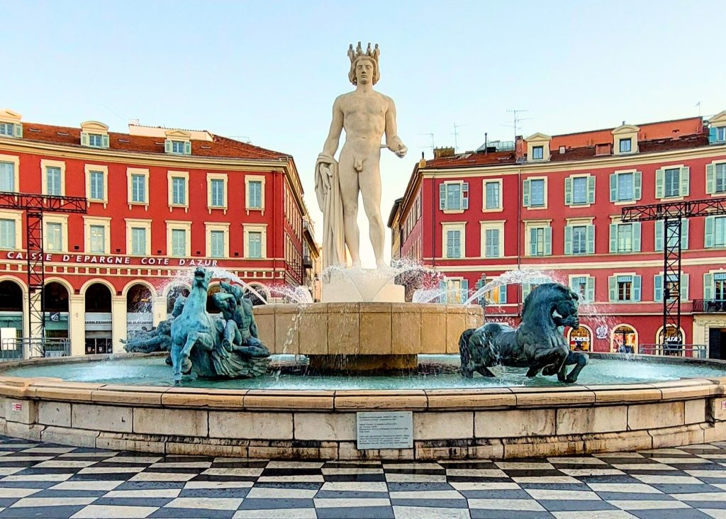 Der Place Masséna in Nizza mit rotem Gebäudeensemble und Springbrunnen an der Côte d’Azur