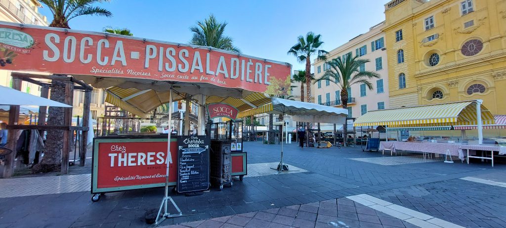 Traditioneller Socca-Stand am Cours Saleya in Nizza, der Socca und Pissaladière anbietet, typische Spezialitäten der Côte d’Azur
